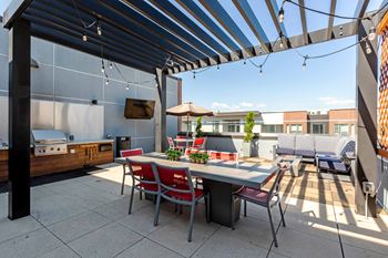 A patio with a table and chairs under a striped awning at Regatta Sloans Lake Apartments, Colorado, 80204